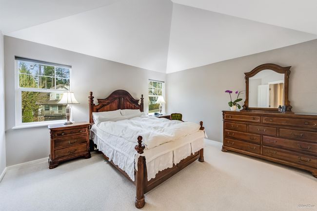 Bedroom with multiple windows, light colored carpet, baseboards, and high vaulted ceiling | Image 14