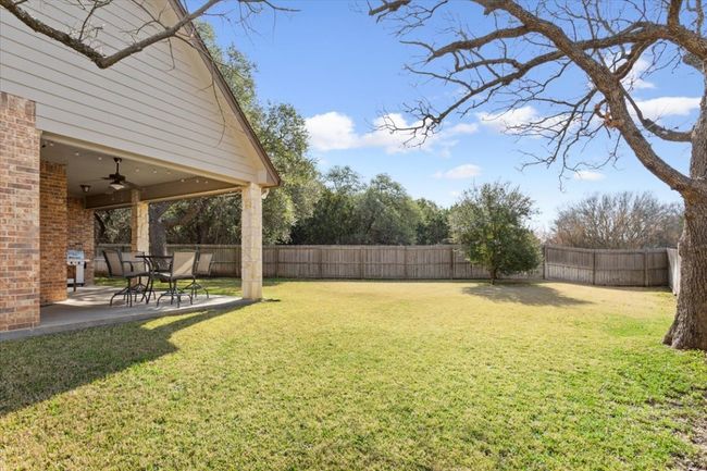 View of yard featuring a fenced backyard, a patio, and ceiling fan | Image 34