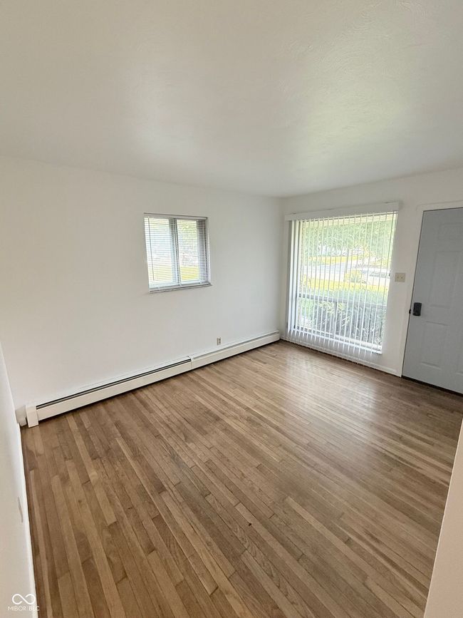 spare room featuring wood finished floors and a baseboard heating unit | Image 4