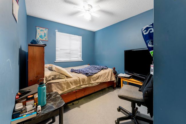 Bedroom featuring a ceiling fan, carpet floors, and a textured ceiling | Image 15