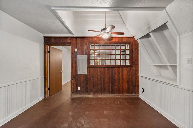 Unfurnished living room with wood accent wall and lofted ceiling | Image 15