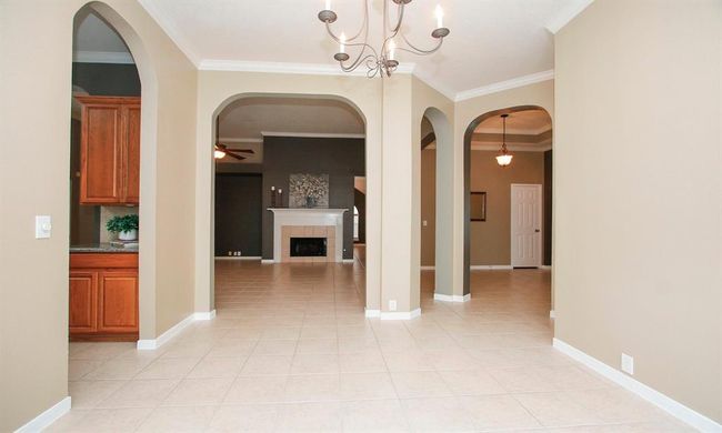 View from the formal dining RM with kitchen to the left and family room ahead. | Image 11