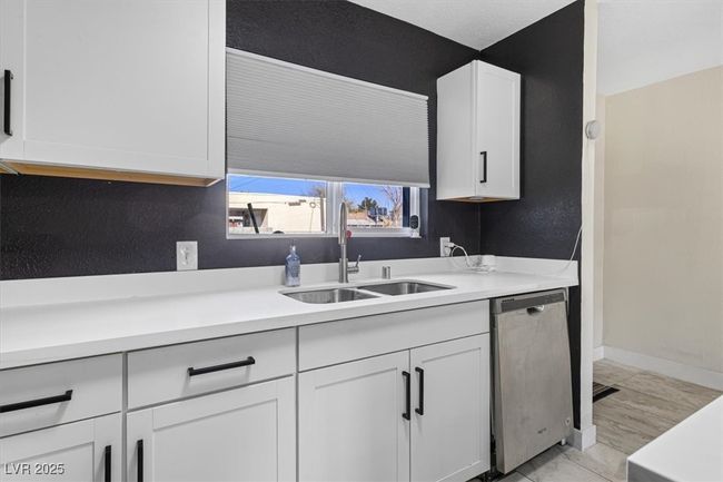 Kitchen featuring dishwasher, white cabinetry, light countertops, and a sink | Image 12