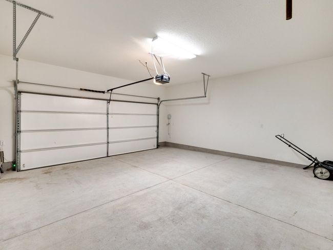 Garage with a garage door opener and baseboards | Image 34