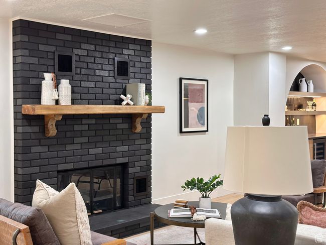 Living room featuring a textured ceiling, a fireplace, recessed lighting, and wood finished floors | Image 26