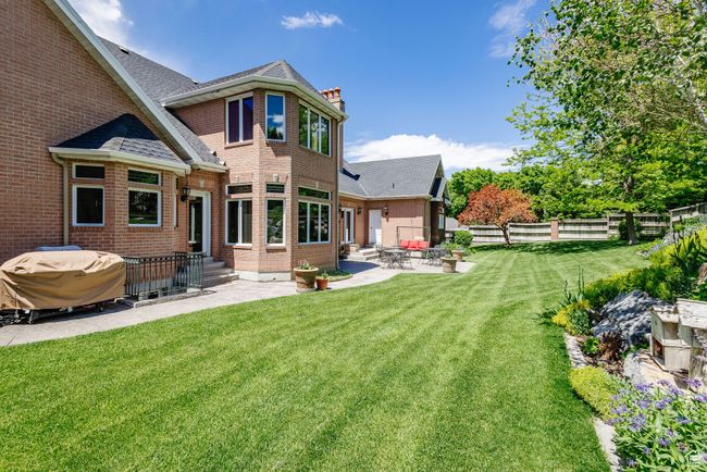 Back of property with a patio area, a fenced backyard, a chimney, brick siding, and entry steps | Image 89