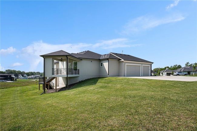 View of front of property with an attached garage, driveway, a front yard, and stairway | Image 66