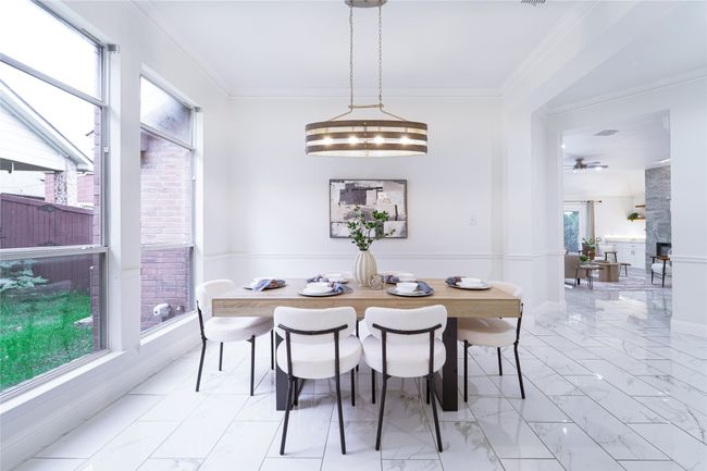 Dining room with light marble finish flooring, a fireplace, a ceiling fan, and crown molding | Image 5