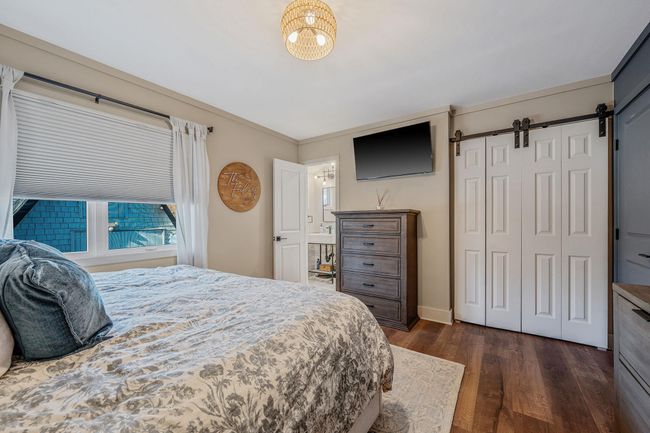 Bedroom featuring a barn door, dark hardwood / wood-style flooring, and a closet | Image 18