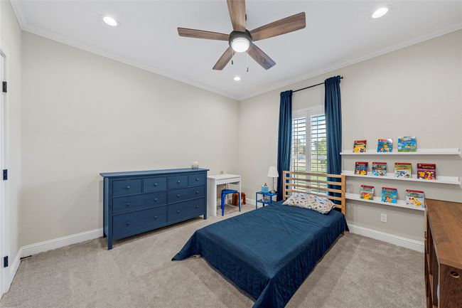 Carpeted bedroom featuring crown molding, baseboards, recessed lighting, and a ceiling fan | Image 16