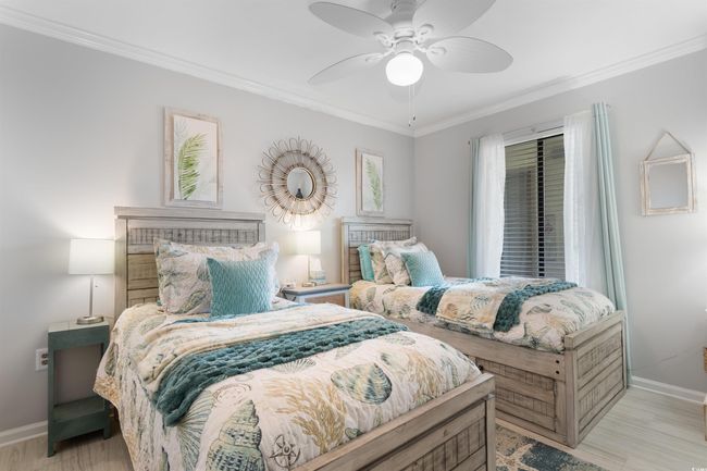 Bedroom featuring baseboards, crown molding, wood finished floors, and ceiling fan | Image 18
