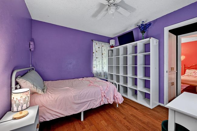Bedroom featuring wood finished floors, a textured ceiling, and ceiling fan | Image 24