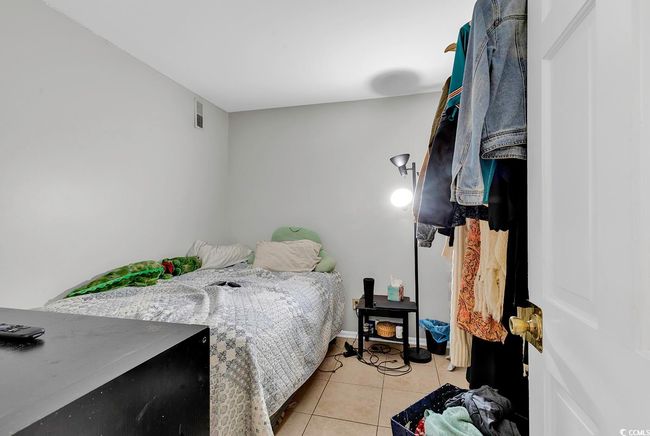 Bedroom with light tile patterned floors, baseboards, and visible vents | Image 20