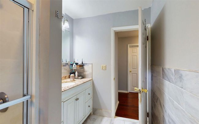 Full bathroom featuring vanity, a shower with shower door, and tile walls | Image 24