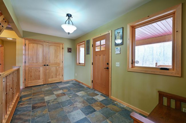 The entry to the main home has a large coat closet and slate floors. | Image 15