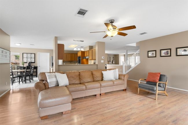 Discover the charm of this inviting living room, adorned with beautiful light wood floors, seamlessly flowing into the kitchen and a cozy secondary dining area. Perfect for entertaining and family gatherings! | Image 16