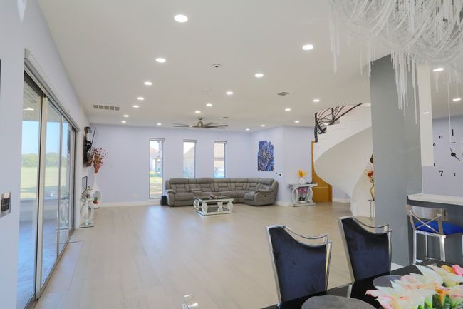Living room with plenty of natural light, ceiling fan, and light wood-type flooring | Image 7