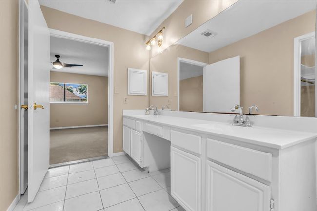 Primary en-suite bathroom features double sinks, a large soaking tub and separate shower. | Image 19