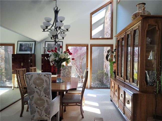 Carpeted dining space with vaulted ceiling and an inviting chandelier | Image 12