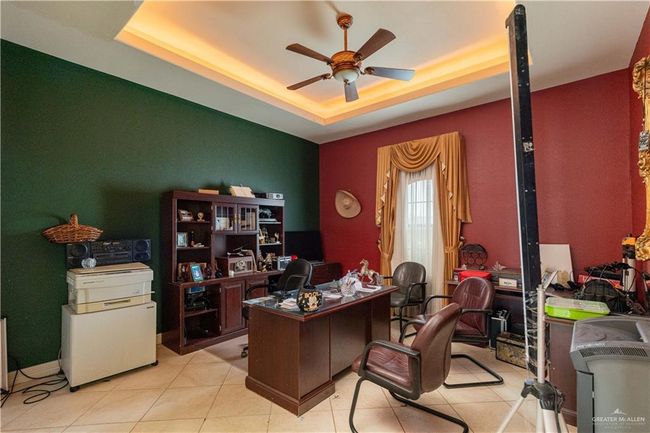 Tiled office space featuring a tray ceiling and ceiling fan | Image 17