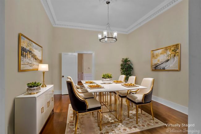 Dining space with crown molding, dark wood-type flooring, and a chandelier | Image 9