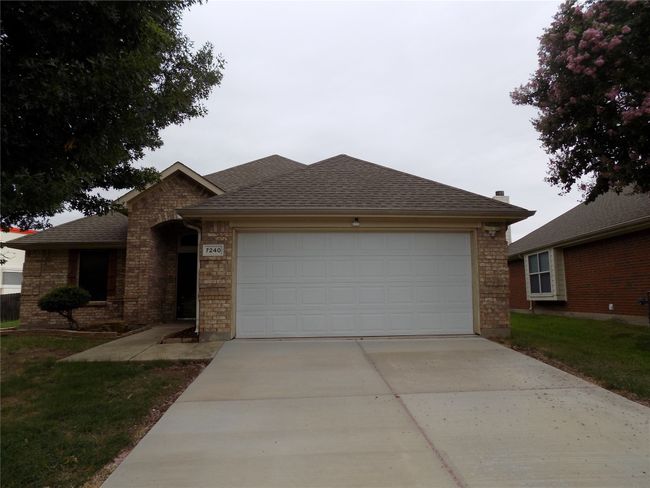 Ranch-style home featuring concrete driveway, a garage, a shingled roof, and brick siding | Image 28