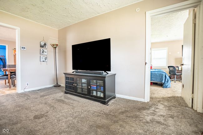 carpeted living area with a textured ceiling and baseboards | Image 5