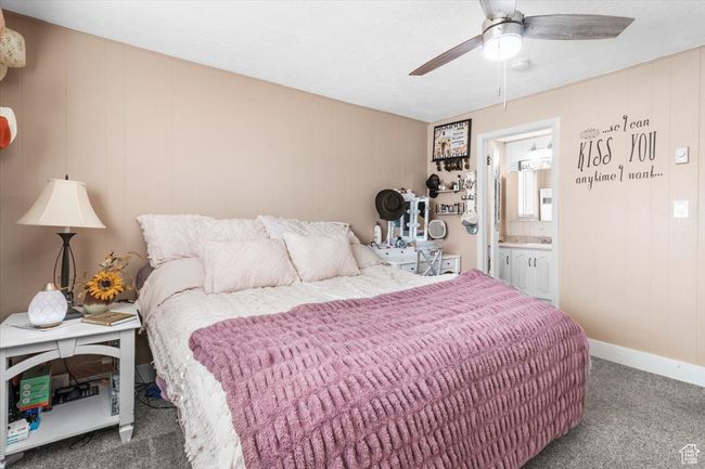 Carpeted bedroom featuring baseboards, ensuite bath, and ceiling fan | Image 32