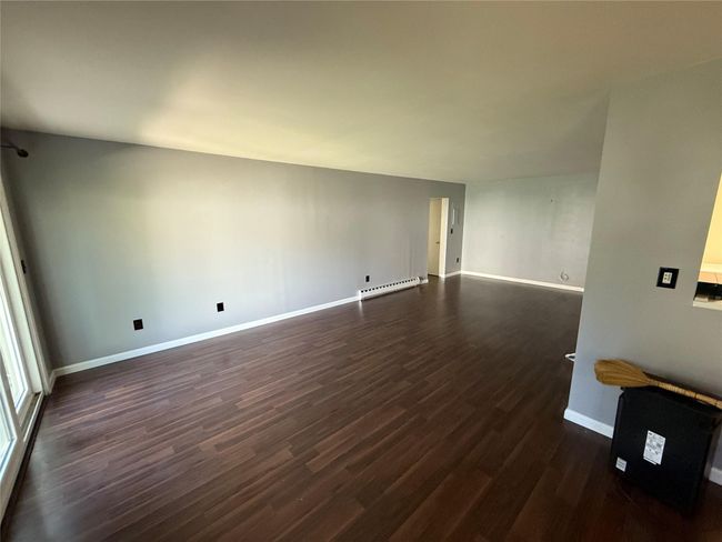 Unfurnished room featuring a baseboard radiator, dark wood finished floors, and baseboards | Image 6
