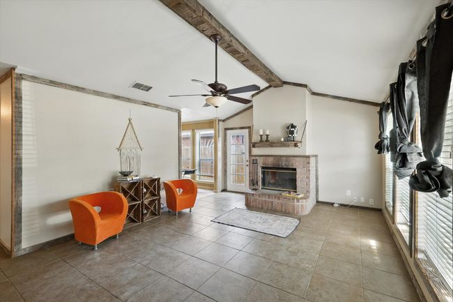Living area featuring a ceiling fan, a fireplace, and tile patterned floors | Image 4