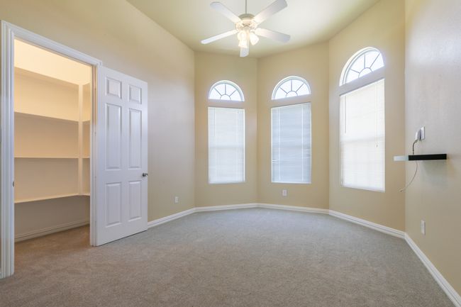 Unfurnished bedroom featuring carpet, a spacious closet, and a ceiling fan | Image 16