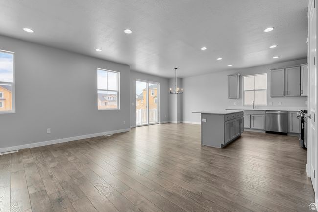 Kitchen with gray cabinets, stainless steel dishwasher, a chandelier, a kitchen island, and recessed lighting | Image 13
