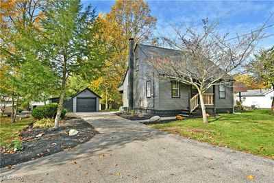 View of front of home featuring an outdoor structure, a garage, and a front lawn | Image 1