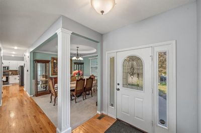 Entrance foyer with light hardwood / wood-style flooring, a chandelier, ornamental molding, and ornate columns | Image 3