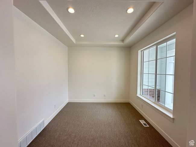 Spare room featuring dark carpet, recessed lighting, a raised ceiling, and a textured ceiling | Image 4