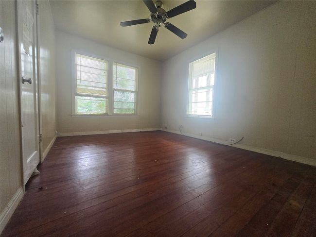 Spare room with wood-type flooring, baseboards, and ceiling fan | Image 9