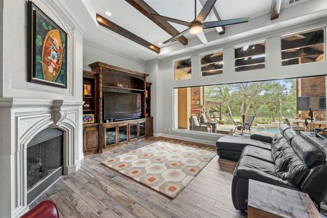 Large living area has built ins and beautiful beamed ceiling with huge fan. | Image 7