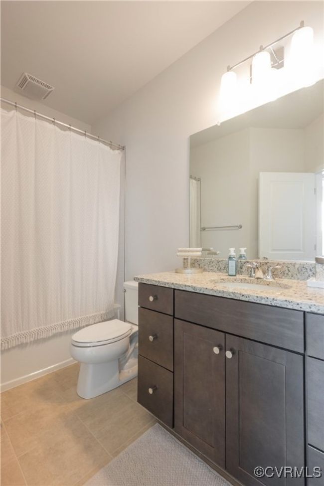 Bathroom with tile patterned floors, visible vents, vanity, and toilet | Image 38