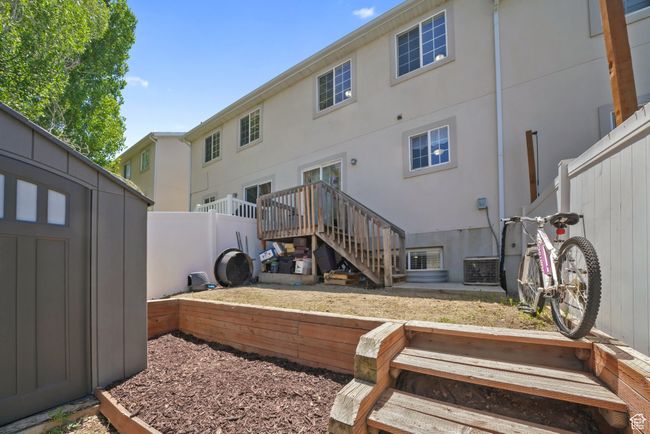 Rear view of house featuring stucco siding and a storage unit | Image 23