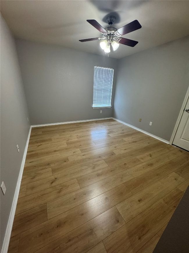 Empty room with a ceiling fan, light wood finished floors, and baseboards | Image 22