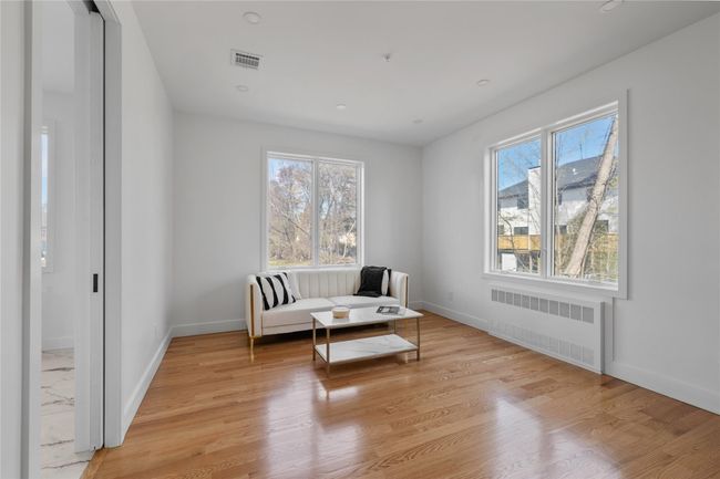 Sitting room featuring light wood-type flooring, baseboards, and radiator | Image 17