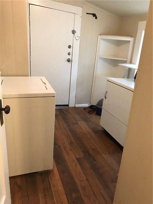 Washroom featuring dark wood-style floors, crown molding, and wooden walls | Image 16