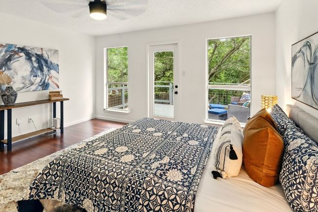 Private primary suite is a true retreat with balcony access overlooking the backyard, refinished hardwood floors, and a luxurious en-suite bath. | Image 11