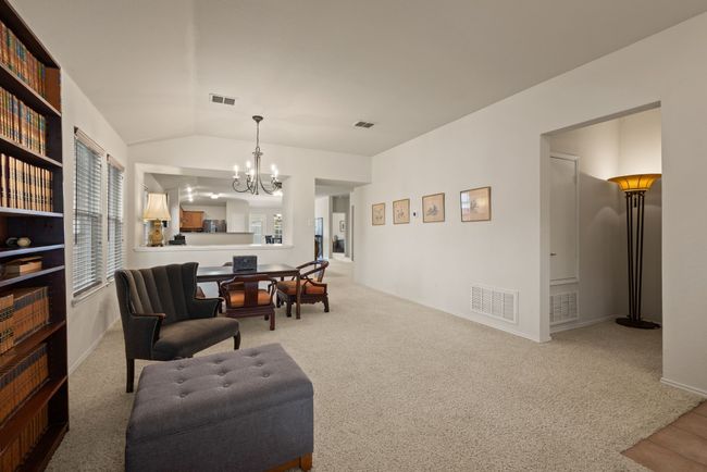 Spacious open-concept layout with dedicated dining area and living space. Room features tall ceilings, plush carpet, and great natural light. | Image 6