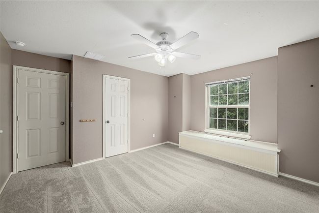 Unfurnished bedroom with carpet, a closet, a ceiling fan, and radiator heating unit | Image 28