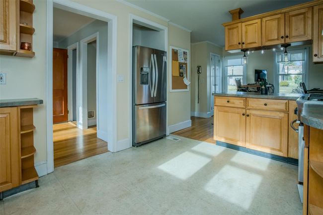 Kitchen featuring stainless steel fridge, ornamental molding, and light hardwood / wood-style flooring | Image 11