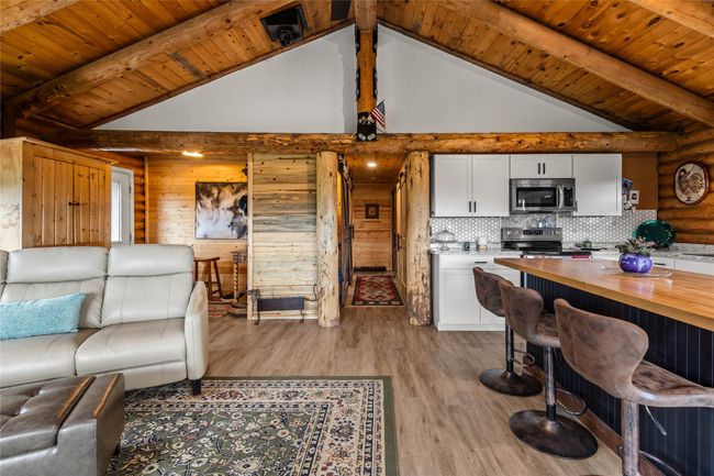 Living room featuring a wooden ceiling with exposed beams, light wood finished floors, and high vaulted ceiling | Image 13