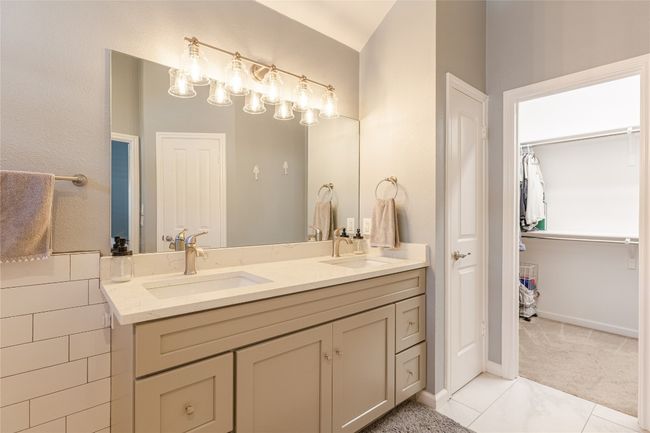 Bathroom with double vanity, tile patterned flooring, and vaulted ceiling | Image 19