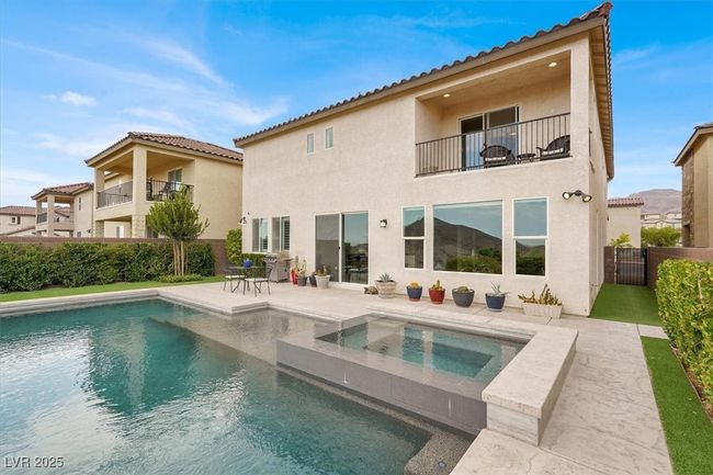 Rear view of property with a balcony, a tiled roof, a patio, and stucco siding | Image 56