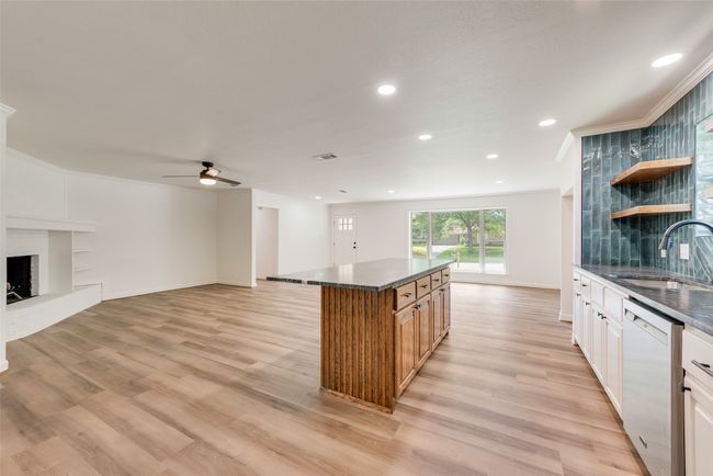 Kitchen with dishwashing machine, dark countertops, light wood-style flooring, a ceiling fan, and recessed lighting | Image 14